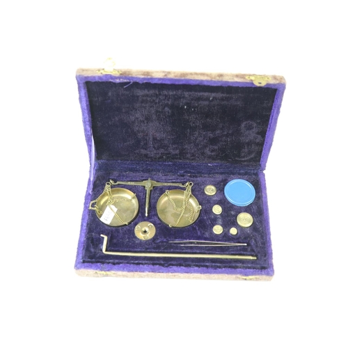 212 - A set of vintage brass scales together with weights within velvet lined case.