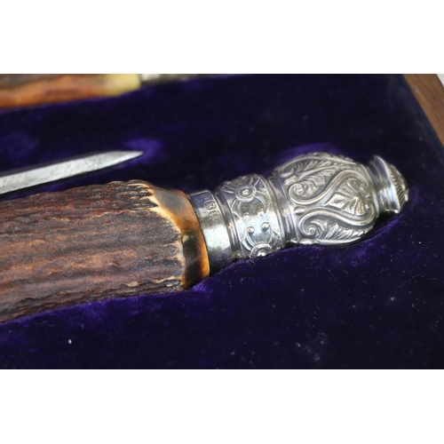 214 - A cased Mappin & Webb carving set with antler handles and hallmarked silver mounts together with a s... 