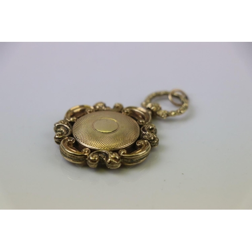 298 - Victorian yellow metal fob, the glazed central panel containing hair, engine turned reverse with sma... 