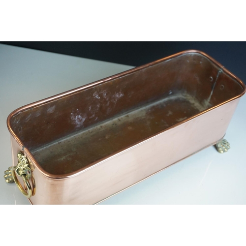 46 - Copper Rectangular Planter with Brass Lion Mask Ring Handles and raised on four brass lion paw feet,... 
