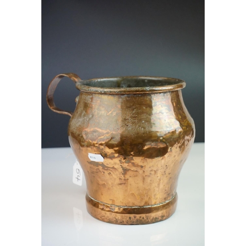 54 - Antique Copper Measuring Pot with a riveted handle, 19cms high