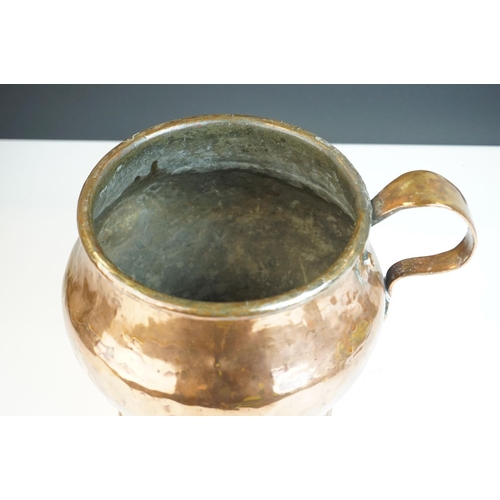 54 - Antique Copper Measuring Pot with a riveted handle, 19cms high