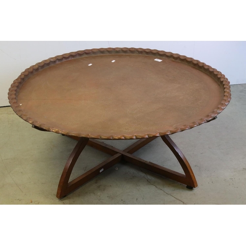 761 - Large Indian / Eastern Circular Copper Tray Top Table, raised on a hardwood folding stand with brass... 