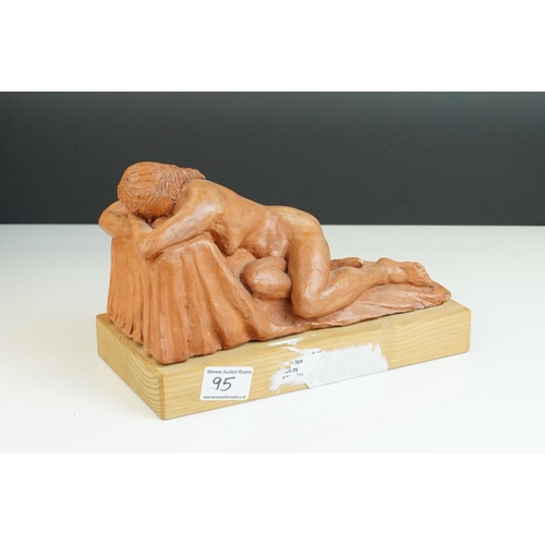 95 - A contemporary sculpture of a recumbent woman raised on a wooden plinth by  Ivor Plummer.