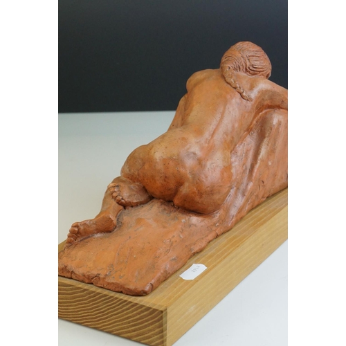 95 - A contemporary sculpture of a recumbent woman raised on a wooden plinth by  Ivor Plummer.