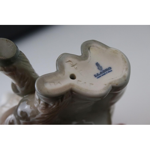 14 - A Lladro figure of a Young boy cuddling a donkey.