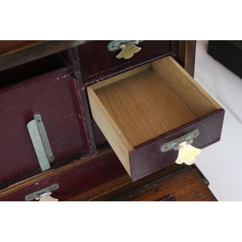 121 - An early 20th century oak stationary cabinet with fitted interior and brass mounts.