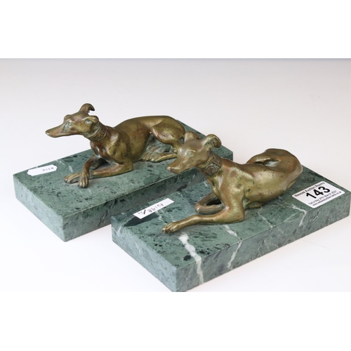 143 - A pair of gilt bronze models of seated greyhounds, together with a pair of bronze dolphin candlestic... 