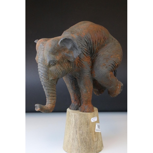 165 - A novelty model of a circus Elephant standing on a plinth with his front legs.
