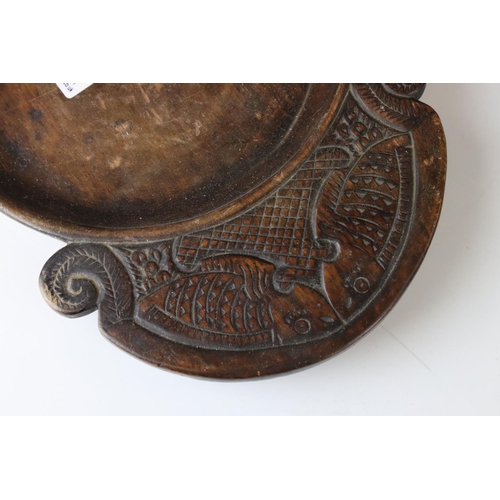 172 - An antique wooden treen collection bowl the handles carved with stylized fish.