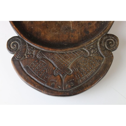 172 - An antique wooden treen collection bowl the handles carved with stylized fish.
