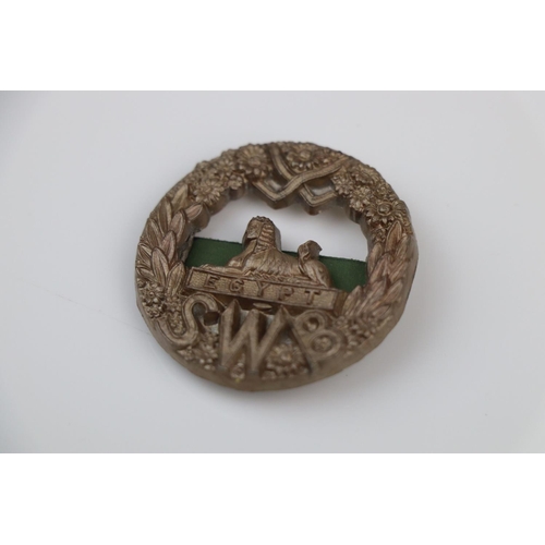 4 - A British World War Two South Wales Border Regiment Plastic Economy Cap Badge With Twin Metal Blade ... 