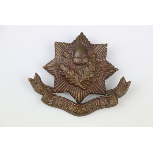 6 - A British The Cheshire Regiment Bronze Cap Badge With Twin Blade Fixings To The Verso.