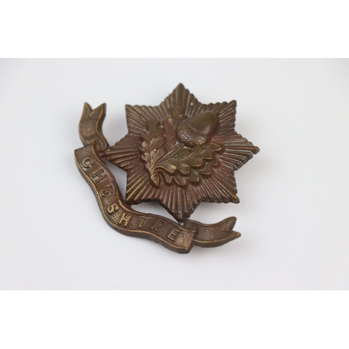 6 - A British The Cheshire Regiment Bronze Cap Badge With Twin Blade Fixings To The Verso.