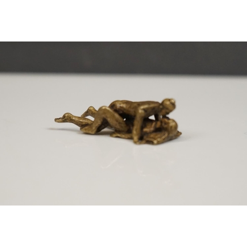 175 - A miniature brass figure of an erotic couple.
