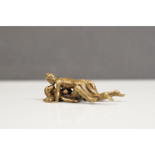 175 - A miniature brass figure of an erotic couple.