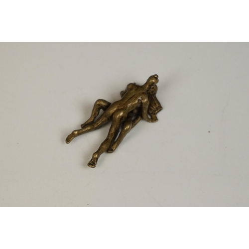175 - A miniature brass figure of an erotic couple.