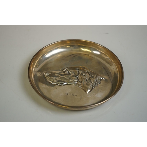 343 - A silver pin tray with hounds head decoration, by John Rose, Birmingham, 1908, 13cm diameter
