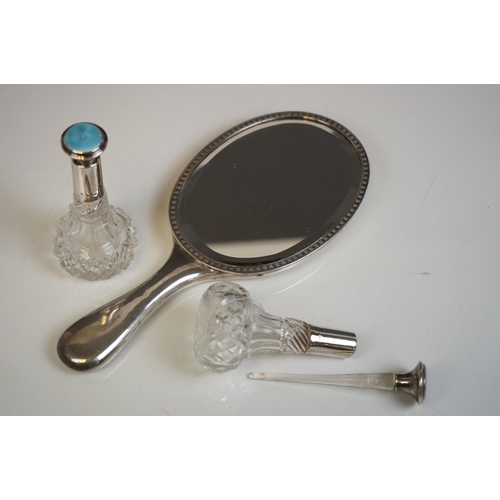 349 - A fully hallmarked sterling silver hand mirror together with two hallmarked silver topped scent bott... 