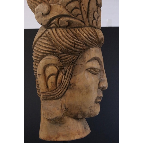 447 - A carved wooden bust of  an Asian woman mounted on a metal base.