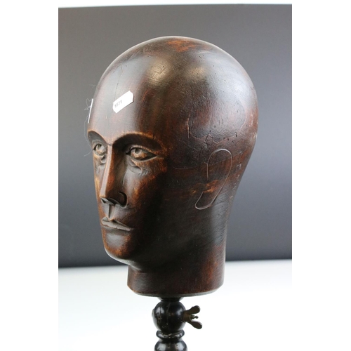 86 - Carved Wooden Man's Head mounted on a turned ebonised clamp. 53cms high