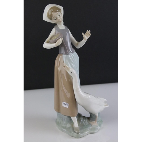 12 - Lladro figure of a lady holding a bowl of feed for goose at her feet