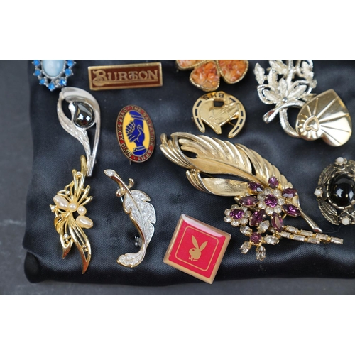 219 - A collection of over thirty brooches and pin badges.