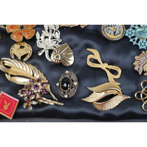 219 - A collection of over thirty brooches and pin badges.