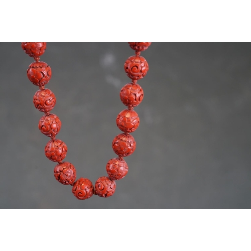 250 - A vintage Chinese Cinnabar beaded necklace with floral decoration.