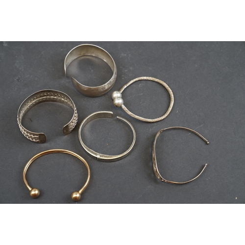 254 - A hallmarked 9ct gold bangle bracelet together with a selection of silver and white metal examples.