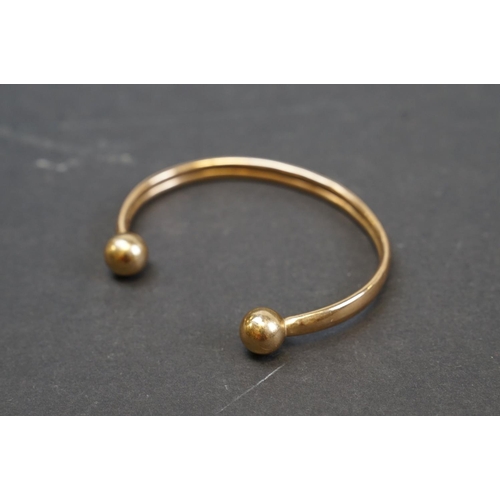 254 - A hallmarked 9ct gold bangle bracelet together with a selection of silver and white metal examples.