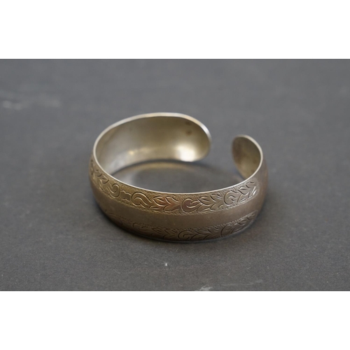 254 - A hallmarked 9ct gold bangle bracelet together with a selection of silver and white metal examples.