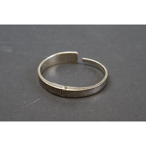 254 - A hallmarked 9ct gold bangle bracelet together with a selection of silver and white metal examples.