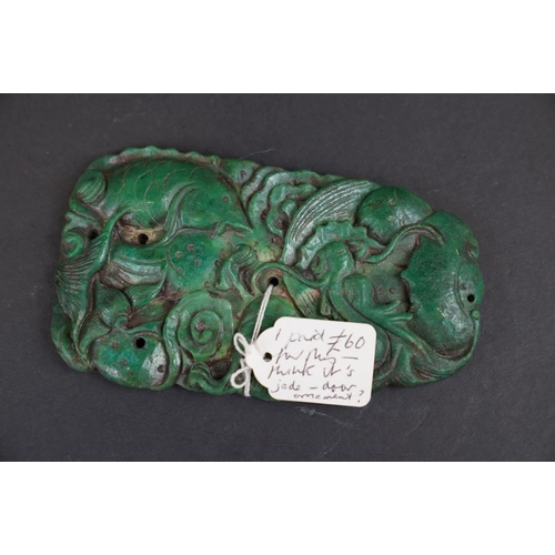 291 - An oriental carved green stone ornament with fish decoration. Measures approx 14.5cm in height.