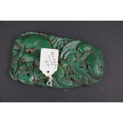 291 - An oriental carved green stone ornament with fish decoration. Measures approx 14.5cm in height.