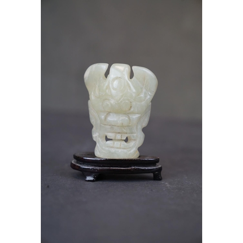 300 - A small collection of three oriental carved Jade ornaments to include a teapot, a seal and a mask on... 