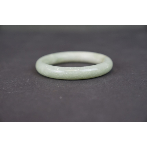 321 - Two oriental carved Jade bangles together with a Jade ring.