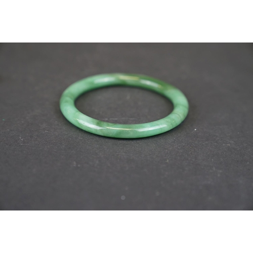 321 - Two oriental carved Jade bangles together with a Jade ring.