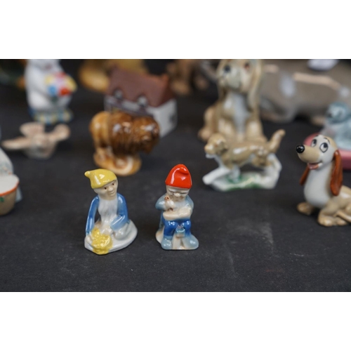 338 - A collection of Wade ceramic ornaments to include animals and houses together with other ceramics.