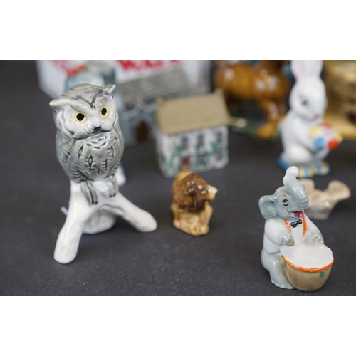 338 - A collection of Wade ceramic ornaments to include animals and houses together with other ceramics.