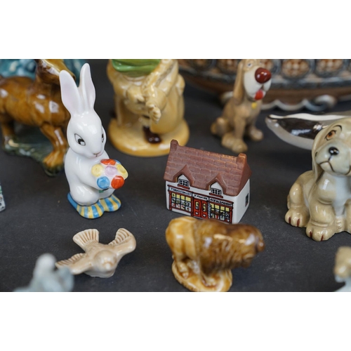 338 - A collection of Wade ceramic ornaments to include animals and houses together with other ceramics.