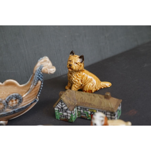 338 - A collection of Wade ceramic ornaments to include animals and houses together with other ceramics.