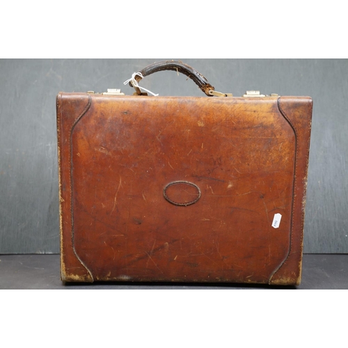 454 - A vintage brown leather suitcase together with a table lamp.