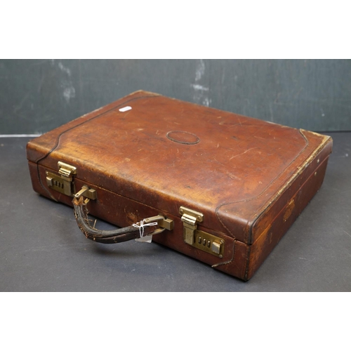 454 - A vintage brown leather suitcase together with a table lamp.