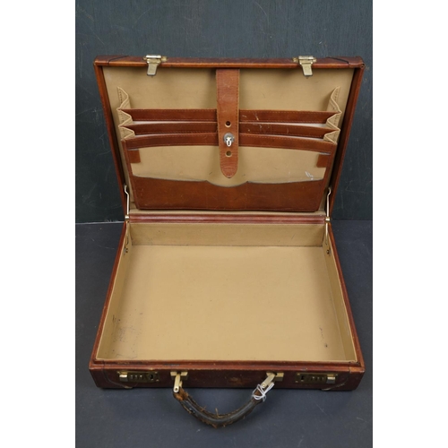 454 - A vintage brown leather suitcase together with a table lamp.