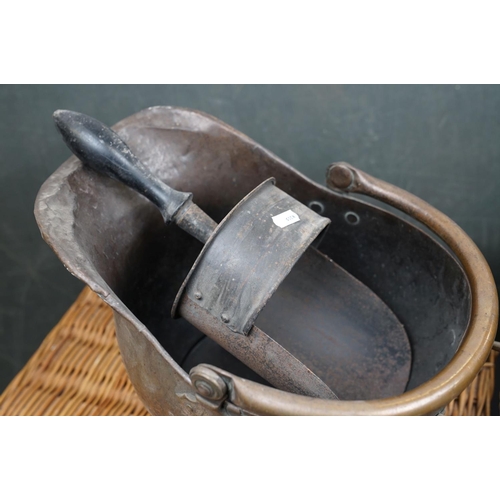 491 - Two vintage copper coal scuttles together with a copper coal bucket, bellows and a wicker basket.