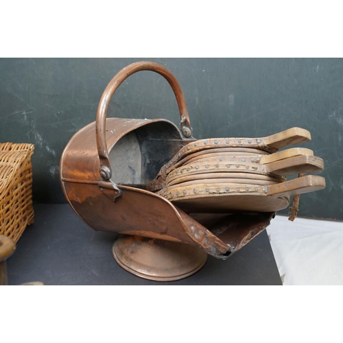 491 - Two vintage copper coal scuttles together with a copper coal bucket, bellows and a wicker basket.