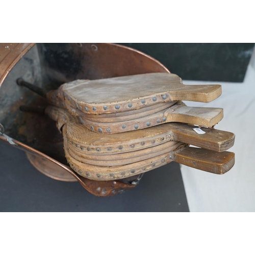 491 - Two vintage copper coal scuttles together with a copper coal bucket, bellows and a wicker basket.