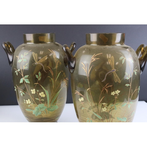 131 - Pair of Early 20th century Green Glass Vases, each with twin loop handles and decorated in enamels w... 