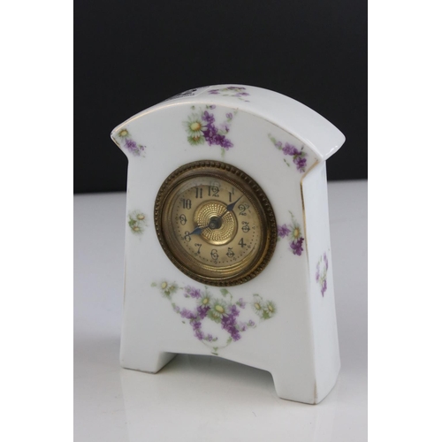 402 - An antique porcelain cased clock with floral decoration.